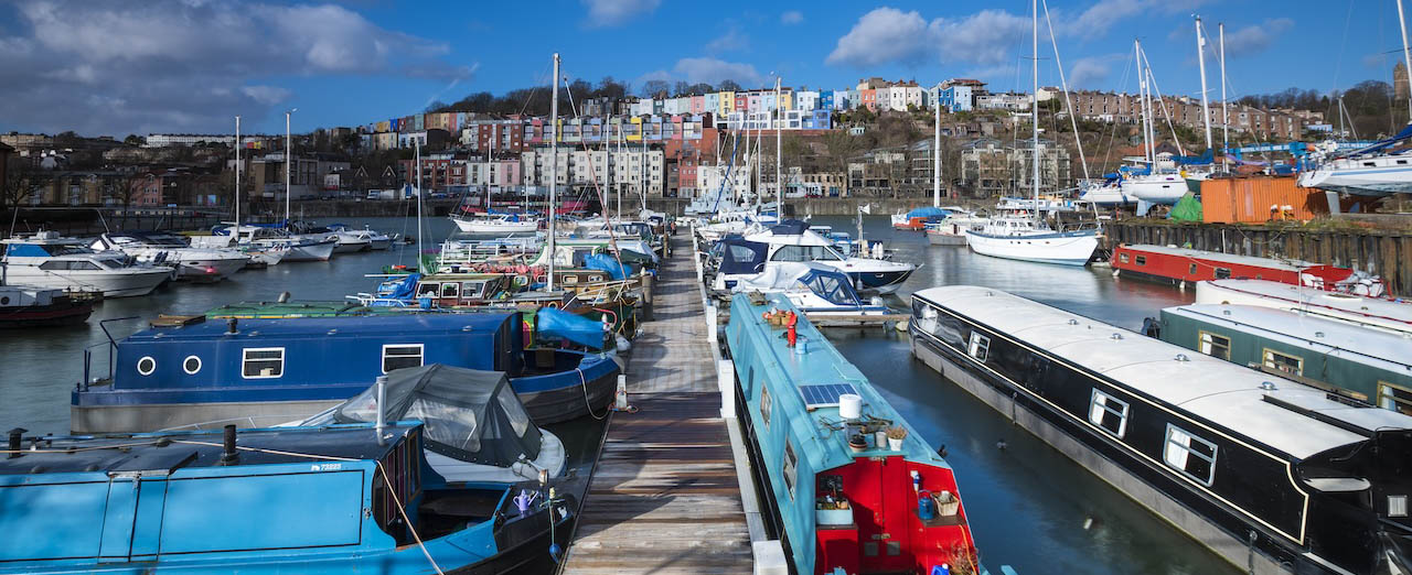lots of boats docked in the harbourside under a bright blue sky